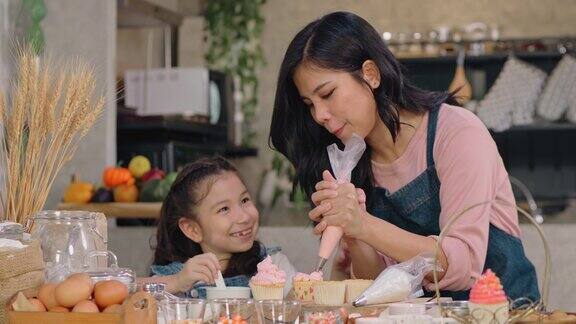 亚洲母亲和女儿在节日里做蛋糕玩得很开心
