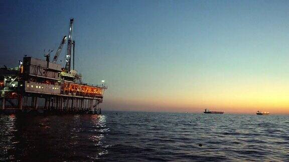 傍晚的天然气和石油海上钻井平台在平静的水域在一个晴朗的傍晚在远处的背景与卡特琳娜岛
