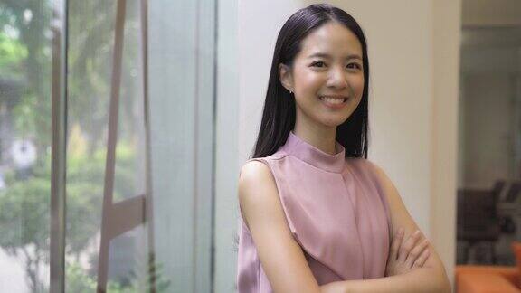 年轻的亚洲女商人双臂交叉在办公大楼里中国韩国亚洲聪明的女士双臂交叉肖像视频