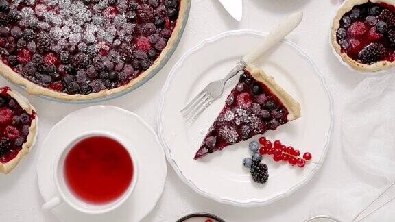 自制的新鲜蓝莓和覆盆子挞靠近桌子上的盘子