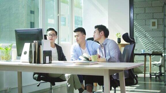 三位亚洲企业家在办公室讨论生意