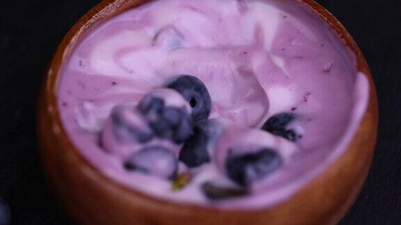 新鲜的紫色和白色酸奶带有蓝莓和蓝莓的味道