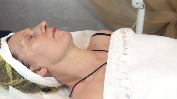 一个成年女子躺在美容院身上盖着白色的毯子美容护肤品