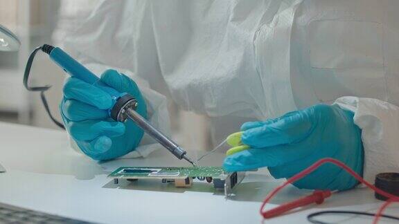工程师戴着手套在实验室焊接PCB