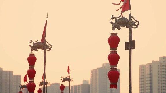中国陕西西安日落时古城墙上的龙旗和灯笼