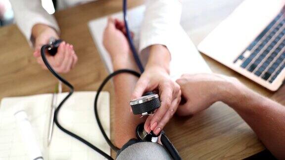 医生在诊所检查病人的血压