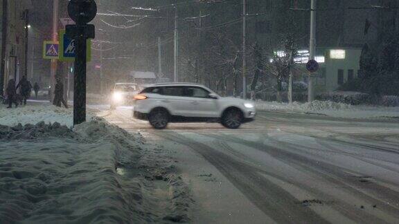 城市道路上的降雪移动的汽车十字路口人们