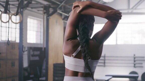 一个年轻健康的女人在健身房锻炼前做热身伸展运动的4k视频片段