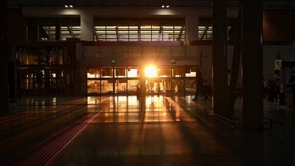 日落时分一些游客在机场候机楼里散步的剪影Covid-19大流行期间的旅行理念