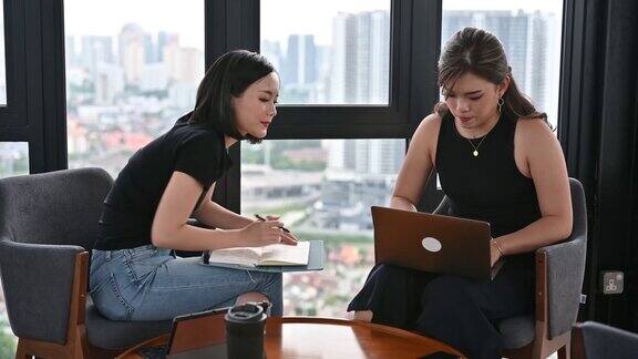 两位年轻的亚洲女商人在联合办公空间成功会面