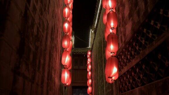 晚上走向古庙狭窄走廊墙间的木阳台点燃了红灯笼四处悬挂着照明灯传统装饰节日庆典