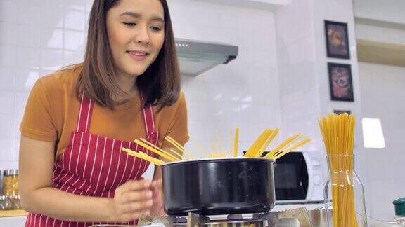 年轻的亚洲妇女在厨房做饭妻子正在为丈夫做一顿特别的饭