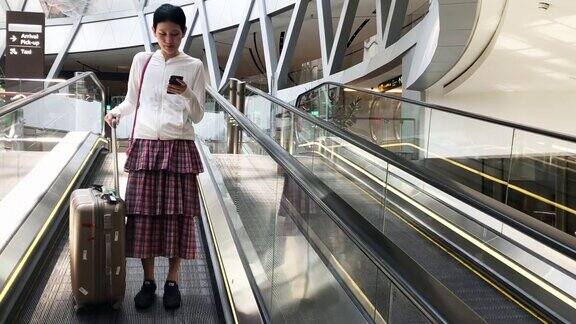 一名女子在机场航站楼使用智能手机