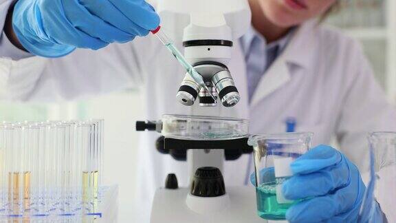 实验室特写:科学家用显微镜滴下培养皿样品