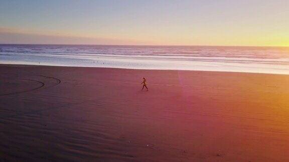 无人驾驶飞机在华盛顿海岸偏远的海滩拍摄孤独的女人