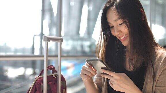 亚洲女性在等待航班时使用智能手机