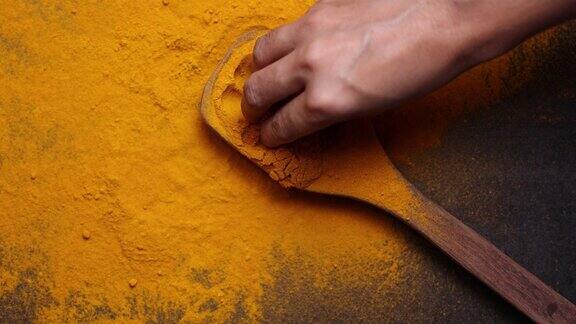 印度香料姜黄粉在木勺落在黑色背景印度喀拉拉邦