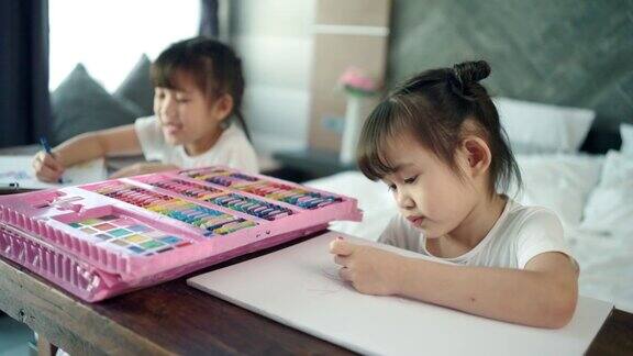 两个女孩在画画在木桌上画画