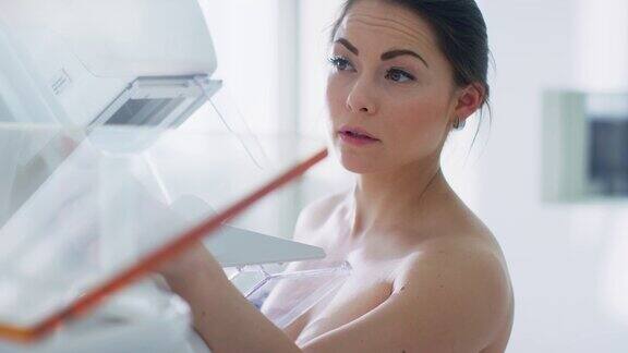 在医院里一名接受乳房x线筛查的半裸女性病人的肖像拍摄健康年轻女性进行癌症预防性乳房x线摄影扫描