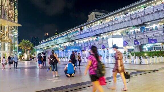 人们在购物中心前的时间流逝和空中火车站的背景