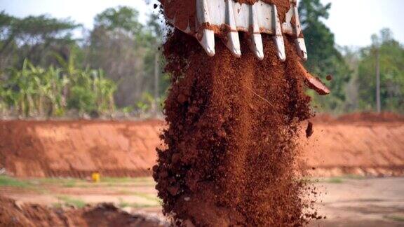 图为挖掘机铲斗在阳光下挖土的慢镜头