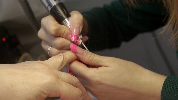 美甲师在美容院用专用器械治疗顾客的指甲硬件修指甲