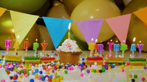 生日的背景是各种年龄的蜡烛奶油纸杯蛋糕与燃烧的蜡烛烟火和气球的背景宝宝生日背景视频