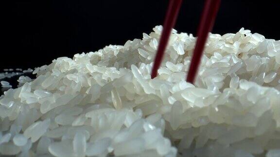 用红色的筷子夹着米饭特写镜头使用筷子