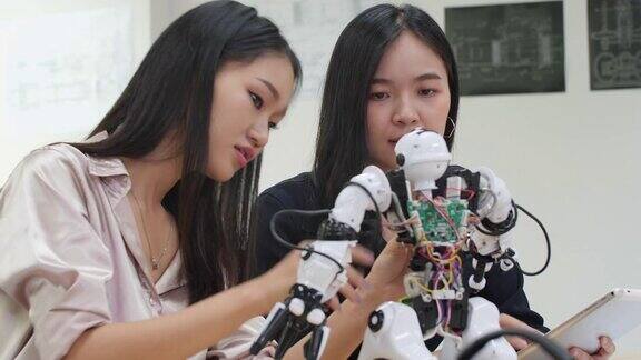 亚洲女工程师在实验室组装和测试机器人反应建筑师设计电路会议分享技术思想和协作开发机器人