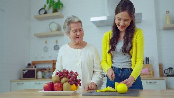 漂亮的亚洲女人在家里的厨房里和老女人做饭