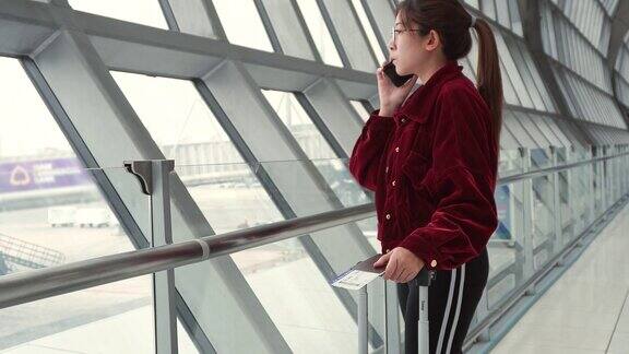 亚洲女性在国际机场使用智能手机查看航班信息等待登机