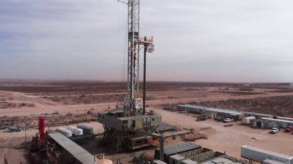 无人机拍摄的西德克萨斯石油和天然气压裂钻机在白天遭遇沙尘暴的画面
