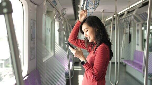 亚洲女性使用手机在Subway上进行社交媒体