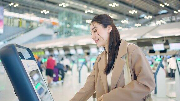 亚洲年轻女旅客在机场候机楼柜台办理登机手续迷人美丽的女游客朋友心情愉快兴奋地乘飞机出国旅游度假旅行