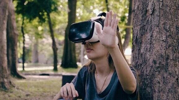 亚洲女性戴着虚拟现实耳机在公园里