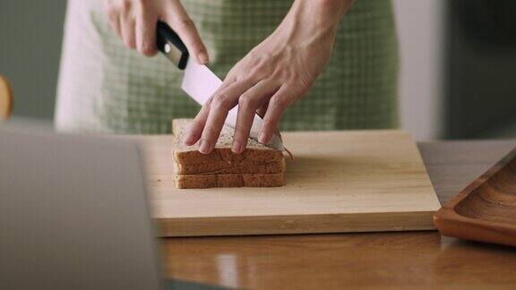 在家里的厨房里用手切蔬菜三明治的特写镜头