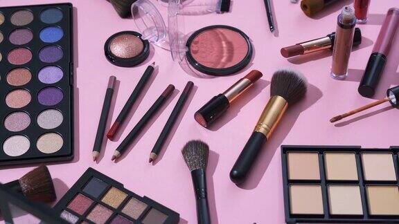 旋转的化妆品和化妆刷收集与侧视图和粉红色的背景
