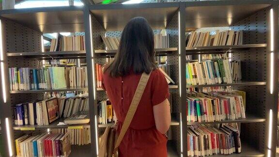 中年妇女走在图书馆里