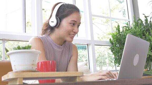 美丽的亚洲女人喝着咖啡在家工作用笔记本电脑开着视频电话会议2019冠状病毒病在家工作的商业理念
