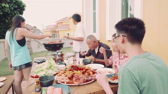 与家人在后院举行的烧烤聚会上做饭的女人