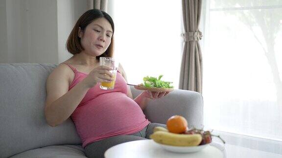 孕妇在家休闲时吃健康食品沙拉、有机食品和果汁