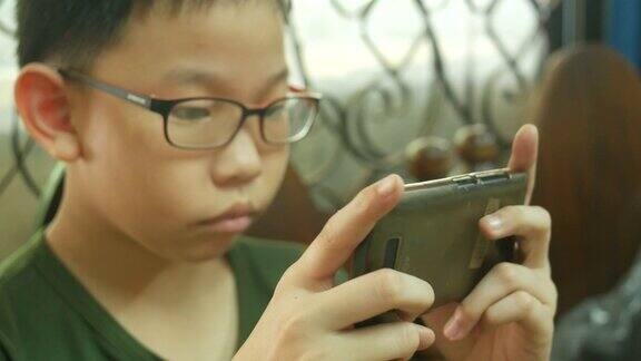 亚洲男孩用智能手机玩数字游戏