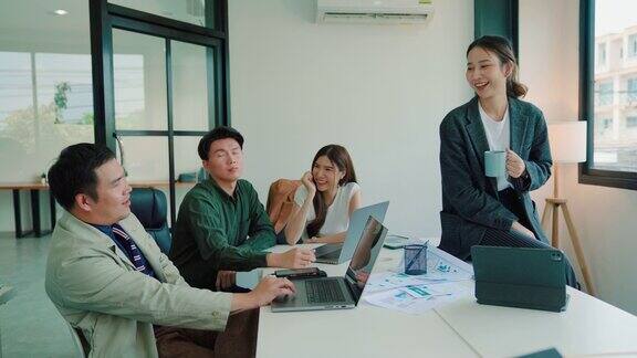 年轻的亚洲女商人在会议室向队友解释研究数据