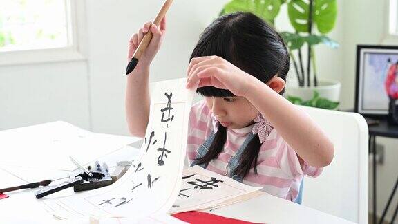 年轻的亚洲女孩在她的小学时代学习中国书法