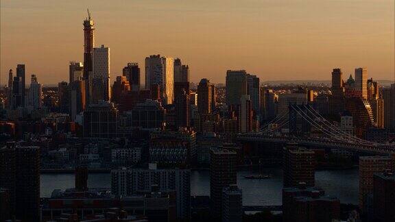 布鲁克林市中心和曼哈顿大桥日落时分的东河和曼哈顿住宅区的远景航拍镜头的平移镜头