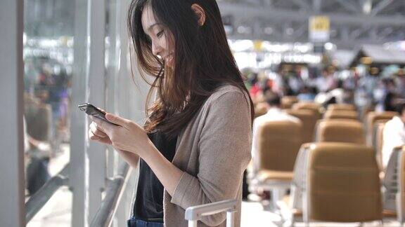 亚洲女性在等待航班时使用智能手机
