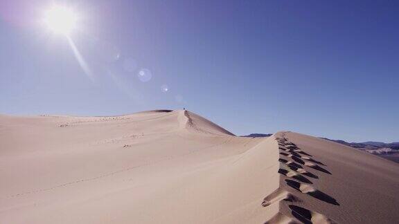 干旱的沙漠景观与远足的足迹在沙