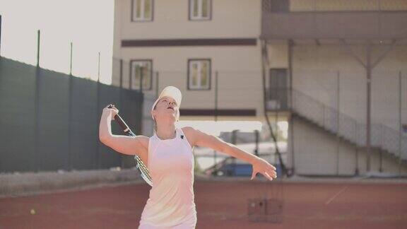 美丽的运动女子网球运动员投球和打击在慢动作