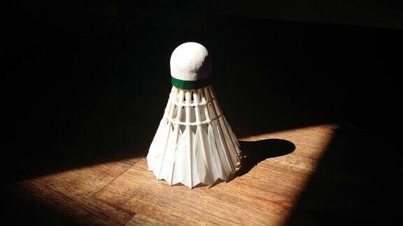羽毛球在一张木桌上在黑暗中形成一个三角形的光
