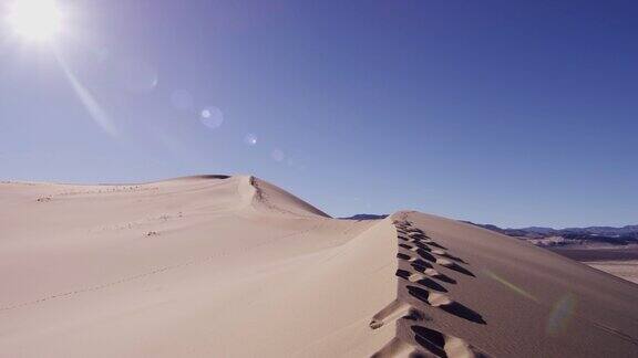 干旱的沙漠景观与远足的足迹在沙